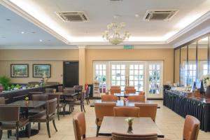a restaurant with tables and chairs and a bar at Merdeka Hotel Kluang in Kluang