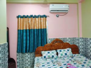 1 dormitorio con 1 cama con cortina azul en Diya Homestay, en Santiniketan