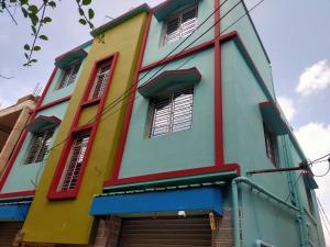 Edificio de colores vivos con ventanas y puertas en Diya Homestay, en Santiniketan