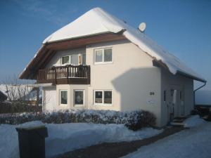 Casa blanca con balcón y nieve. en Ferienwohnung Erholung am Hainich, en Bischofroda