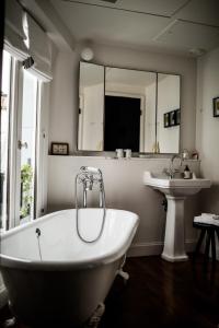 ein Badezimmer mit einer weißen Badewanne und einem Waschbecken in der Unterkunft Le Pigalle, a Member of Design Hotels in Paris + 51 Fotos