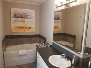 a bathroom with a tub and a sink and a bath tub at Peachland Lake View Spectacular! in Peachland +12 photos