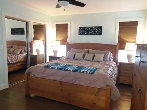 a bedroom with a large wooden bed and a mirror at Peachland Lake View Spectacular! in Peachland