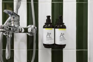 two bottles of alcohol are sitting on a bathroom wall at Sugar Marina Resort-LAGOON-Villas, Naiyang Beach in Nai Yang Beach