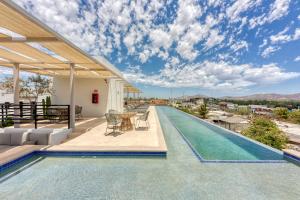 a swimming pool with a table and chairs next to a house at Lumina at Cardinal San José del Cabo in San José del Cabo