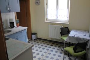 a kitchen with a table and chairs and a sink at City-Apartment "royshell" in Güstrow