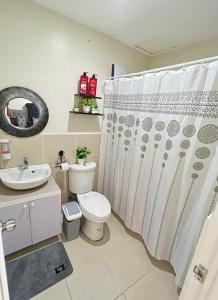 ein Badezimmer mit Toilette und Duschvorhang in der Unterkunft Betty's Midori in Antipolo