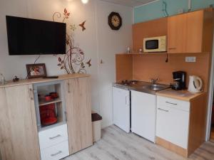a kitchen with a sink and a tv on the wall at Ferienwohnungen Güstrow in Güstrow