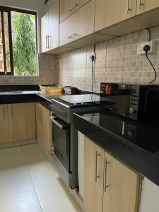 a kitchen with black counter tops and a stove at One bedroom in Bamburi in Mombasa