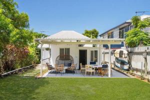 a patio with a table and chairs in a yard at Cosy Cottage - Scarborough Beach in Scarborough