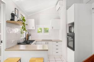 a white kitchen with white cabinets and a sink at Cosy Cottage - Scarborough Beach in Scarborough +20 photos