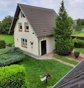 a white house with a black roof and a yard at Ferienhaus LEA in Grabowhöfe