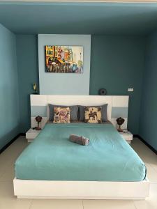 a bedroom with a large bed with blue walls at Nai Harn Beach Condo (C2) in Rawai Beach +10 photos