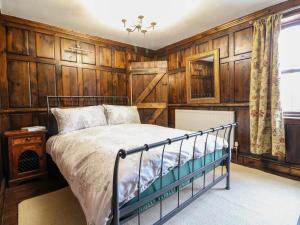 a bedroom with wood paneled walls and a bed at Woodpit Cottage in Nottingham +27 photos