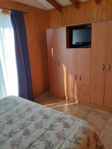a bedroom with a bed and a tv on a cabinet at Casa Jardín del Mar- Reñaca Beach-Frente a Unimarc in Viña del Mar +2 photos
