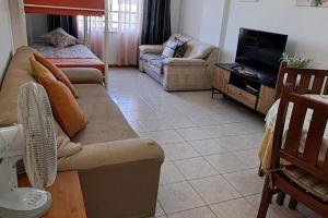 un soggiorno con un divano e una TV di Lisbon Beach Flat - 4 Guests - Free Parking a Costa da Caparica