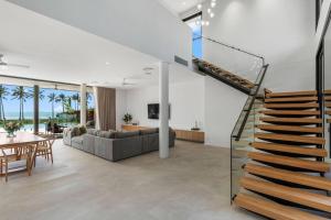 a living room with a staircase and a dining room at Jasper in Airlie Beach