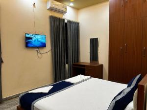 a bedroom with a bed and a tv on the wall at Kashyaam Inn in Varanasi