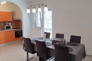 a kitchen with a dining room table and chairs at Family-friendly apartments with swimming pool Vinisce, Trogir - 12676 in Vinišće