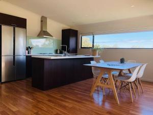 una cucina con tavolo, sedie e bancone di Architecturally Designed Rural Retreat a Forcett