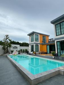 a large swimming pool in front of a house at Dertera Poolvilla เดอเทร่าพูลวิลล่า หาดใหญ่ in Hat Yai
