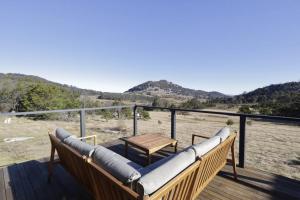 a balcony with a couch and a table on a deck at Off-Grid Farm Stay with Scenic Views in Tenterfield