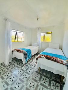 a bedroom with two beds and a tiled floor at Airport Cottage - Private Twin Room in Fua‘amotu