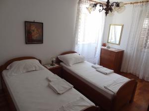 two twin beds in a bedroom with a window at Inn Town Center in Hvar