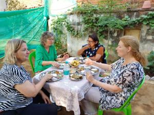 a group of women sitting around a table eating food at Orchha Best Homestay in Orchha +88 photos