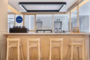 bar z czterema stołkami przy ladzie w restauracji w obiekcie Holiday Inn Express Bali Sunset Road by IHG w mieście Kuta