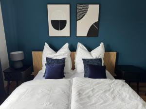 a bedroom with blue walls and a bed with pillows at Sankt Göres Suites in Düsseldorf