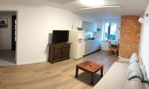 eine Küche und ein Wohnzimmer mit einer Couch und einem Tisch in der Unterkunft Apartament Parkowy in Jedlina-Zdrój