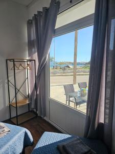 a bedroom with a window with a view of the beach at Beach Apartment A in Nea Karvali
