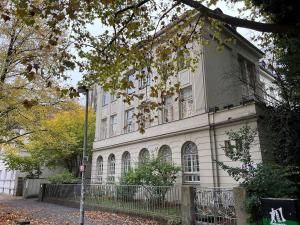 a large white building with a fence in front of it at Gästezimmer Familie von der Tann in Hannover