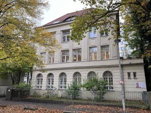 a large white building with a fence in front of it at Gästezimmer Familie von der Tann in Hannover