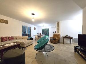 un soggiorno con un divano e una TV di Le Parc Jean Édouard - Spa avec jacuzzi privé - Superbe villa 4 chambres - 9 couchages - 6 lits - Poêle - Parking - Climatisation réversible- Terrasse ombragée et grand jardin a Montech