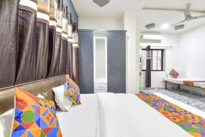 a bedroom with a large bed with colorful pillows at FabExpress Soni Palace in Ujjain +19 photos