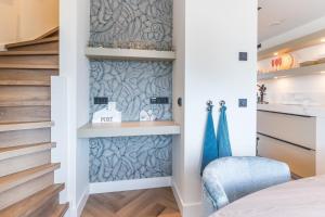 a bedroom with a bed and a blue chair at The Boathouse Lodge in Harderwijk