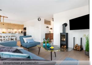 a living room with a blue couch and a fireplace at Der Küstengruß in Olpenitzdorf