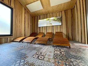 a row of wooden benches in a room with a screen at Mobilheim 6 Personen MH9 in Hindenberg
