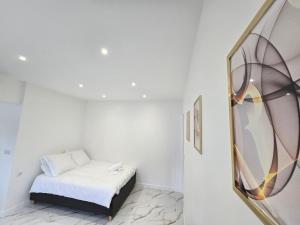 a small white room with a bed and a mirror at Ô Sacrée Détente de Reims -Spa privatif - Proche de la gare & centre ville in Reims