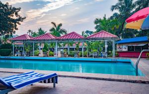 a pool at a resort with a restaurant at Toshali Sands Nature Escape Puri in Puri