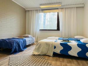 a bedroom with two beds and a window at Voionmajoitus in Ylöjärvi