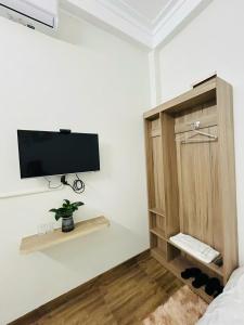 a room with a tv on a wall with a cabinet at Nhím Hotel MC - by BAY LUXURY in Mộc Châu +10 photos