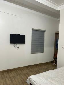a bedroom with a flat screen tv on the wall at Nhím Hotel MC - by BAY LUXURY in Mộc Châu