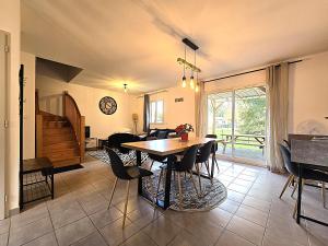 a dining room with a table and chairs at Le Clos Andrée - Charmante maison 8 personnes - 5 lits - Climatisation réversible RDC - Parking 3 véhicules - Garage - Zone Nord Montauban - Terrasse et jardin in Montauban