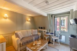 a living room with a couch and a table at Dolphin View - 2nd floor - Beautiful flat with view of the port in Honfleur