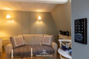 a room with a couch and a speaker on the wall at Dolphin View - 2nd floor - Beautiful flat with view of the port in Honfleur