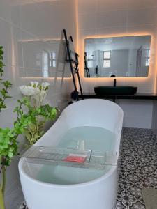 e bagno con vasca e specchio. di Brand new house with Karaoke room near to jonker Netflix 18 pax by Doraee Home a Malacca