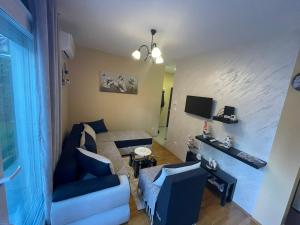 a living room with a couch and a tv at Apartman Bella vita 2 in Zlatibor